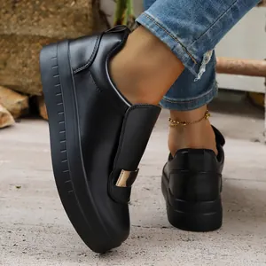 Detailed view of stylish black platform sneakers with elegant gold buckle on top