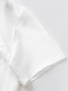 Close-up of white textured fabric and sleeve detail on men's casual short-sleeved set