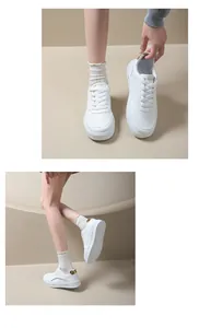Vue détaillée de baskets à plateforme blanches avec détails dorés au talon portées par un mannequin.