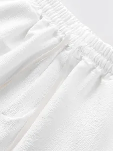 Detail of white textured fabric and drawstring waistband on men's summer shorts