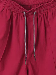 Close-up detail of mens red linen shorts showing elastic waistband and patterned drawstring