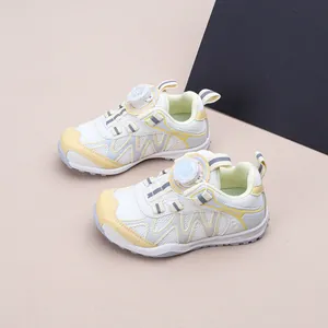Détail de chaussures de sport pour enfants en blanc et jaune avec système de laçage rotatif.