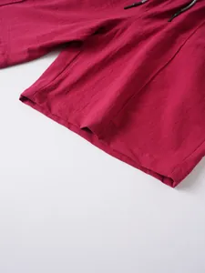 Macro detail of red linen men's beach shorts showing premium fabric texture and hem