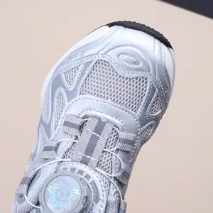 Gros plan sur chaussure de running enfant argentée avec boucle rotative et mesh.