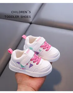 Dettaglio ravvicinato delle scarpe sportive bianche per bambini con lacci rosa e motivi