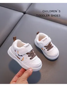 Dettaglio di sneakers bianche per bambini con lacci marroni e suola morbida antiscivolo.