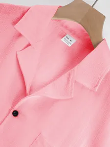 Macro detail of men's pink summer casual shirt featuring pleated texture and size tag