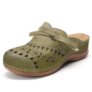 Detaillierte Seitenansicht von olivgrünen Damen-Clogs mit Keilabsatz und Lochmuster-Design