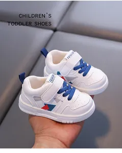 Scarpe da ginnastica per bambini in microfibra bianca con lacci blu e motivi rossi.