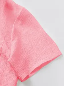 Macro detail of pink textured fabric sleeve from men's casual short sleeve set