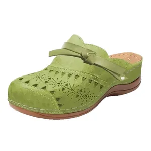 Modische avocadogrüne Keil-Clogs für Damen mit Lochmuster-Blumen und Plateau-Sohle.