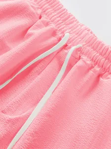 Macro detail view of pink men's casual shorts with elastic waistband and drawstring
