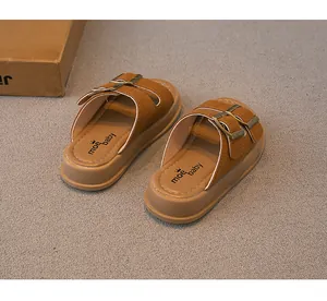 Nahaufnahme brauner Wildleder-Kindersandalen mit Doppelschnallen und dicker hellbrauner Sohle.
