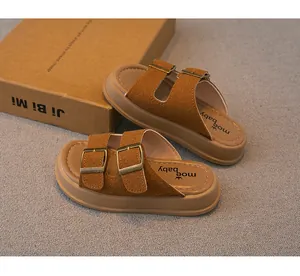Detaillierte Nahaufnahme von braunen Wildleder-Kindersandalen mit Metallschnallen