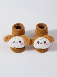 Detalle de calcetines de invierno para bebé con adorables caras de perro en 3D soft