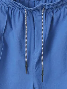 Close-up of blue linen beach shorts with elastic waist and drawstring detail