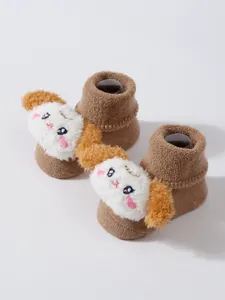 Vista detallada de calcetines de suelo para bebé con adorno de cara de perro en peluche 3D.