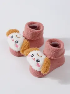 Primer plano de calcetines de rizo rosa para bebé con un lindo animal de dibujos 3D
