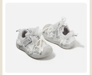 Detailed view of silver baby girl sneakers with pearl beads and tulle bow accents
