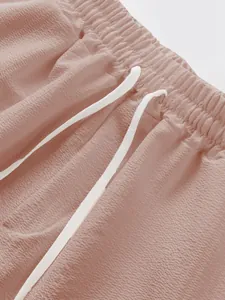 Close-up detail of men's pink drawstring shorts showing textured fabric