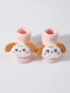 Primer plano de calcetines rosa para bebé con un lindo personaje de cachorro de peluche en 3D