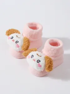 Detalle de calcetines gruesos y cálidos para bebé con cara de cachorro 3D en relieve