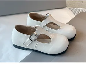 Klassieke crème T-strap Mary Jane schoenen voor meisjes met zilveren gesp detail.