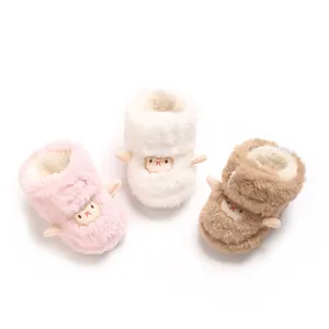 Gros plan de trois bottes d'hiver pour bébé en rose, blanc et marron avec mouton