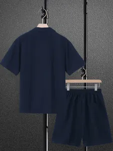 Rear view of men's navy blue short sleeve shirt and matching loose casual shorts set