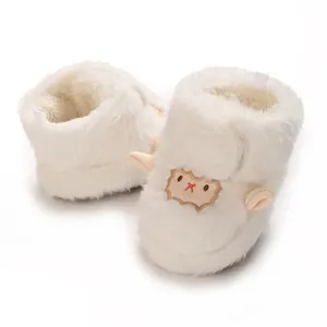 Gros plan de bottes bébé en peluche blanche douce avec broderie de mouton mignon