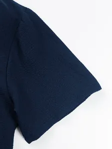 Detailed macro view of the navy blue textured fabric on a men's casual short-sleeved shirt.