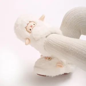 Gros plan détaillé de bottines en peluche blanche pour bébé avec motif d'agneau mignon