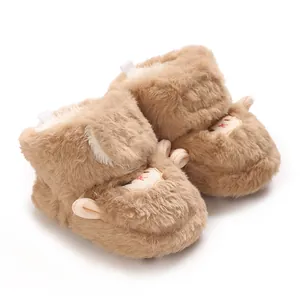 Gros plan détaillé de chaussons pour bébé en fourrure marron avec de jolies oreilles.