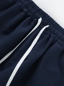 Close-up of navy blue casual shorts with white drawstring and elastic waistband detail