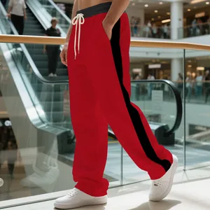 Macro detail of red men's sweatpants featuring black side stripes and drawstring