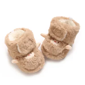 Gros plan sur des bottes de bébé en peluche marron avec broderie d'agneau mignonne et douce.