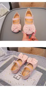 Dettaglio scarpe rosa da bambina con fiocco di perle e decorazioni scintillanti