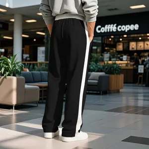 Rear view of men's heavy black sweatpants with contrast white side stripes in a mall