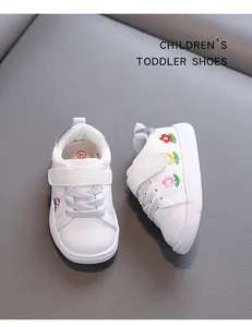 Detailansicht weißer Kleinkinderschuhe mit bunten, bestickten Blumenmustern