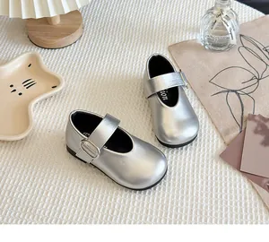 Top view of silver Mary Jane shoes for girls on a cozy textured background