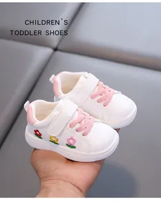 Nahaufnahme von Kleinkinderschuhen mit Blumenstickerei und rosa Klettverschluss