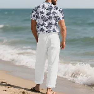 Vista trasera de camisa hombre estampado cocotero y pantalón lino blanco en la playa