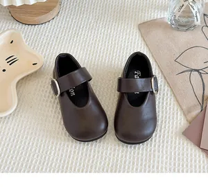 Classic brown girls' Mary Jane leather shoes presented in a stylish lifestyle setting