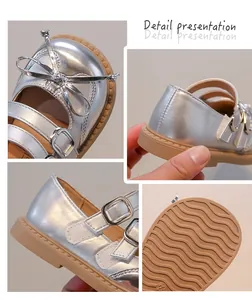 Detailed close-ups of silver Mary Jane shoes for girls with bow and wavy sole.