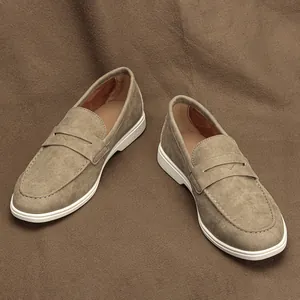 Detail view of men's khaki suede loafers with classic white rubber soles and stitching.