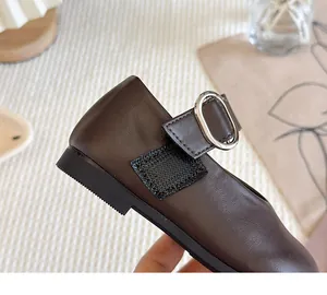 Detailed view of dark brown girl's Mary Jane shoes with silver buckle and velcro