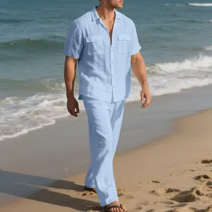 Vista completa del conjunto de lino azul claro para hombre sobre la arena de playa
