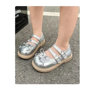 Detail view of shiny silver girls' Mary Jane shoes with double straps and bows
