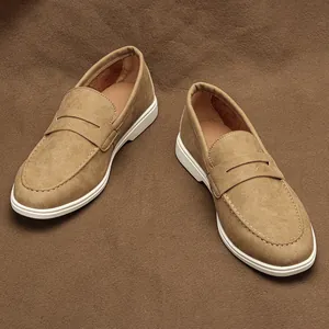 Detailed view of tan suede men's loafers with white soles and classic slip-on design