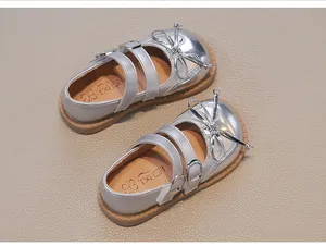 Top view of silver girl's princess shoes with shiny bow and double buckle straps.